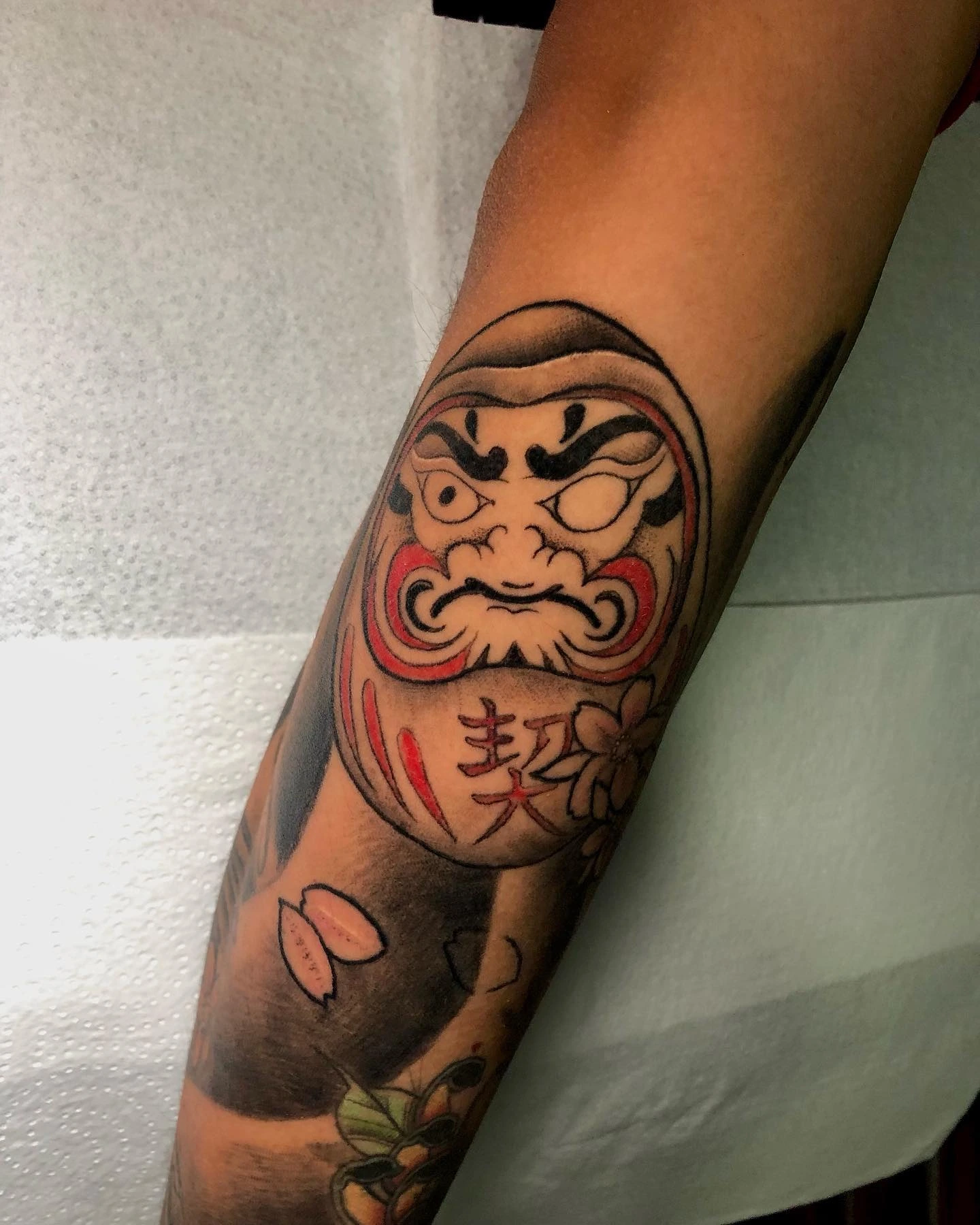 Daruma doll with kanji and cherry blossoms