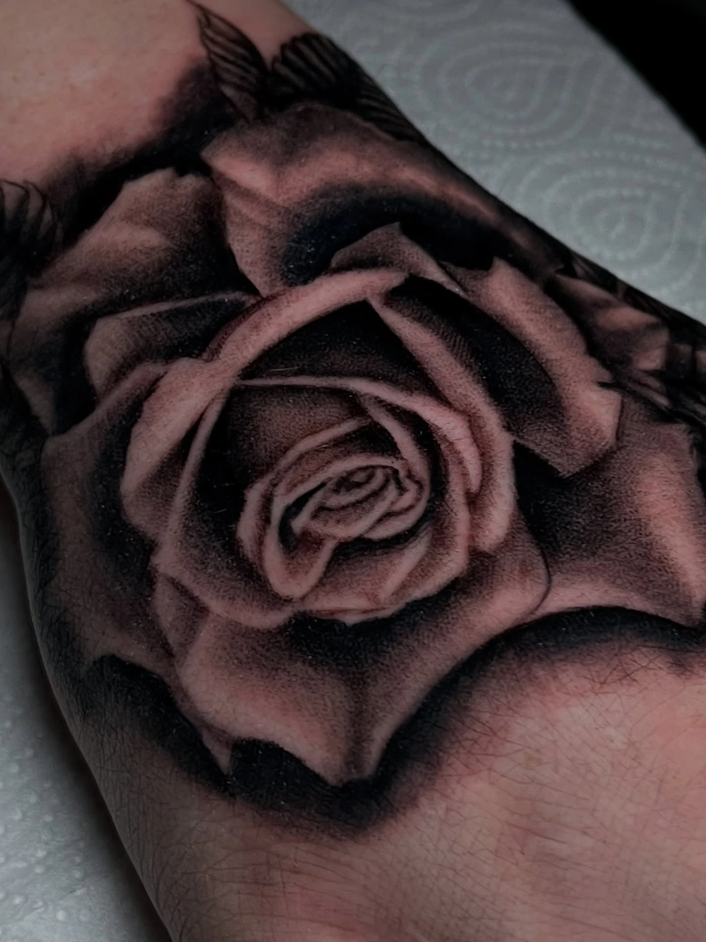 Hyperrealistic black & grey rose on the hand