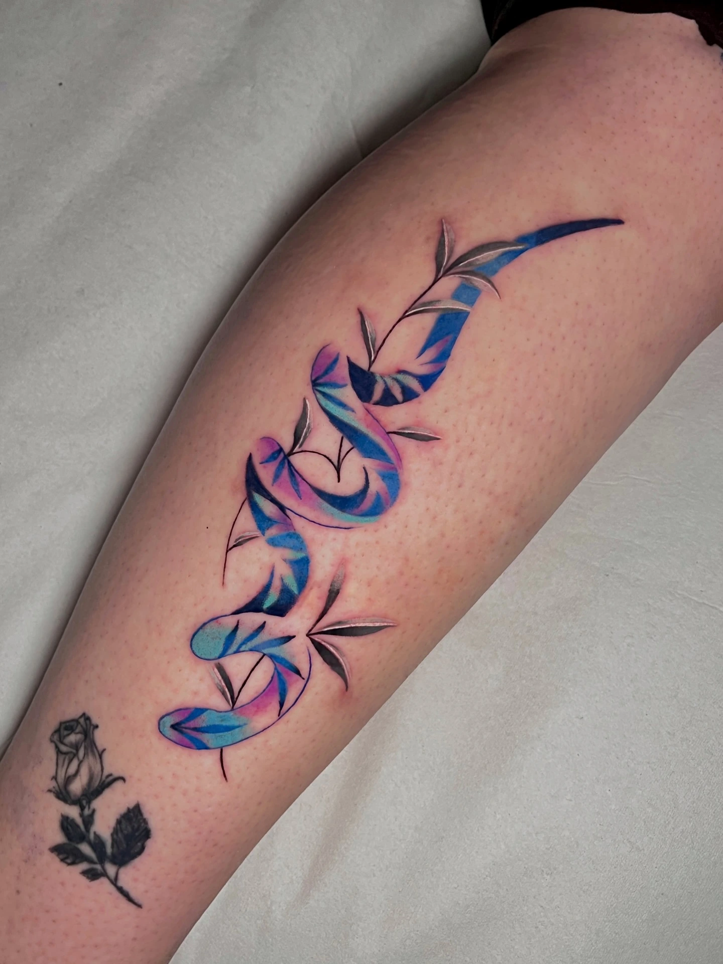 Watercolor blue/purple botanical leaves cascading down forearm