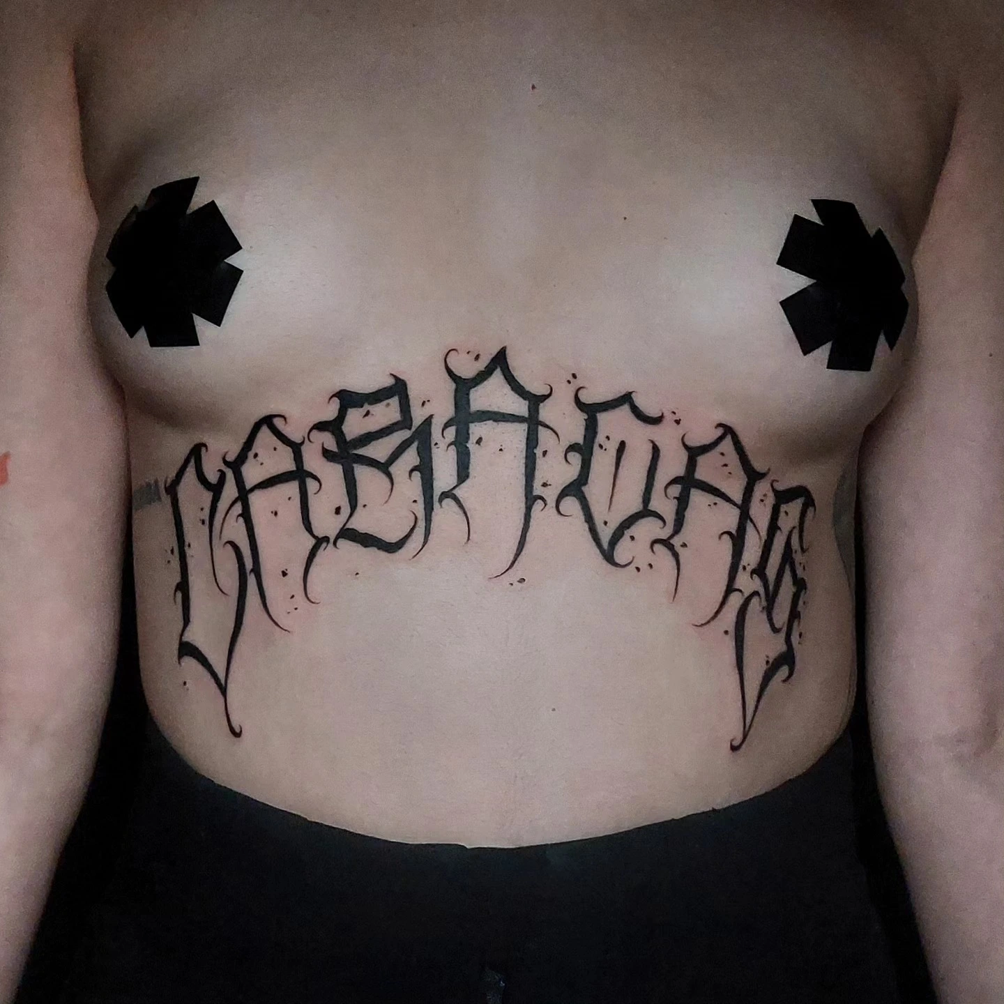 Chicano filigree lettering across underbust/sternum