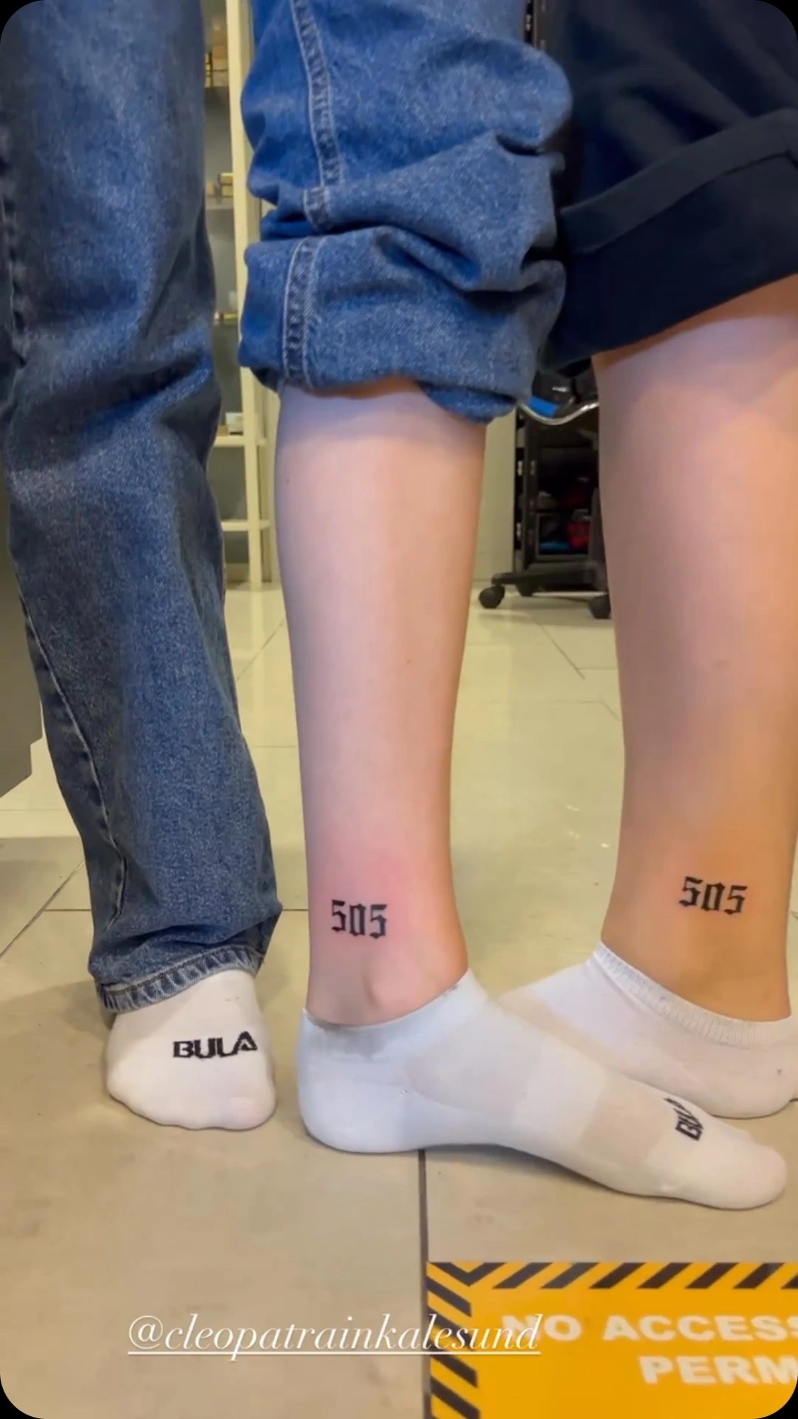 matching '505' Old English numerals on calves of two people