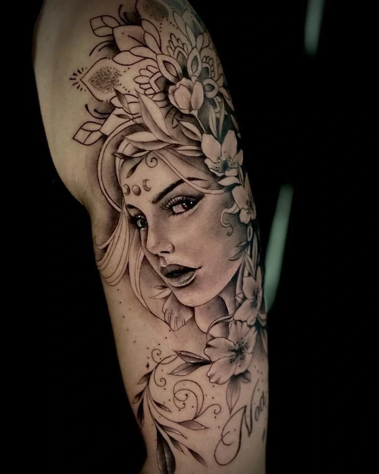 fineline woman face with mandala/floral headdress and 'Noa' lettering